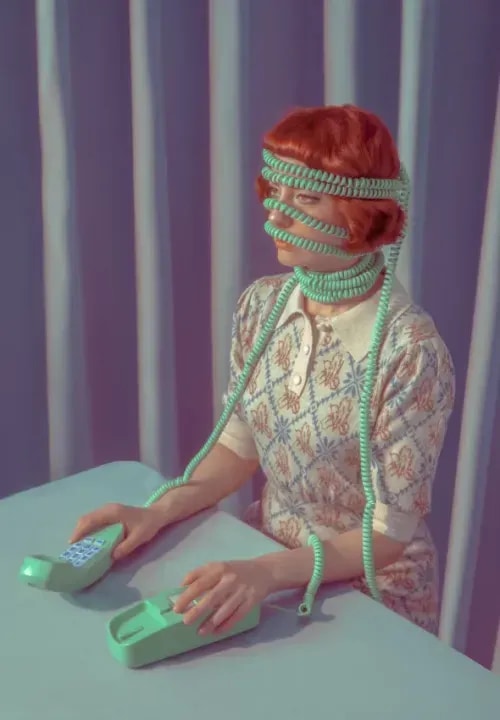 A retro image of a woman sitting at a table with a telephone wire wrapped around her.